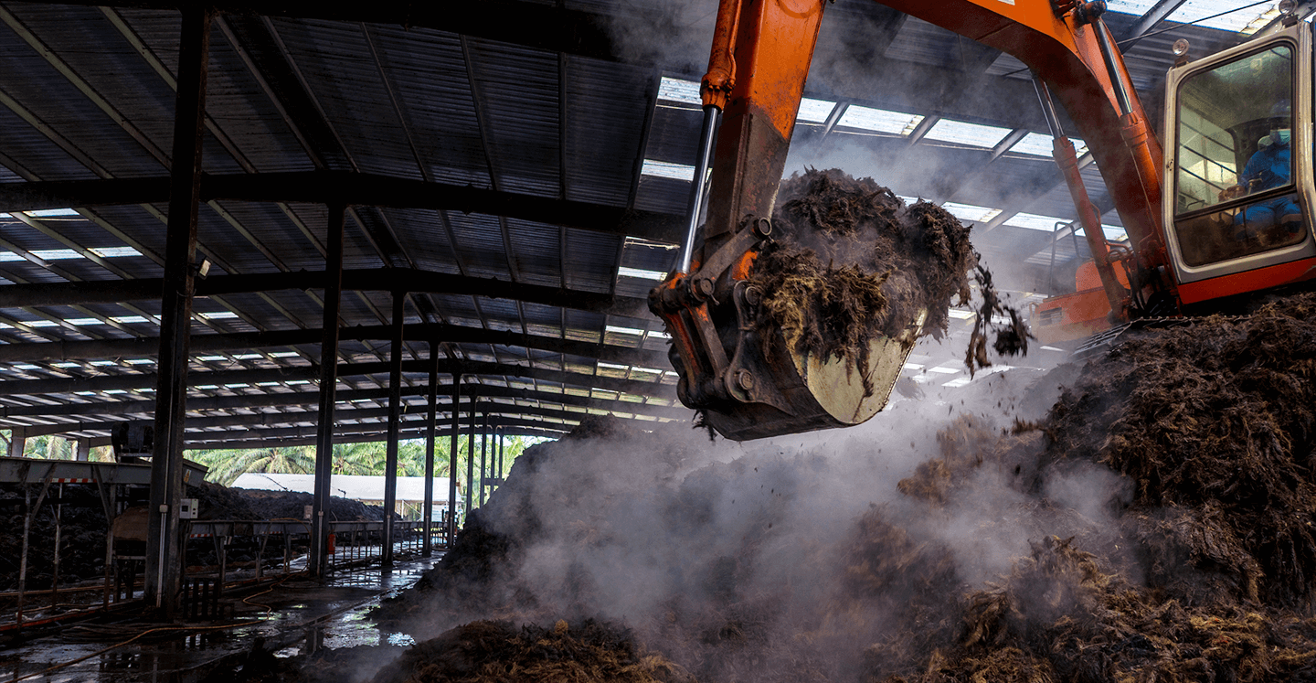 Excavator handling steaming mill biomass at an AMR site